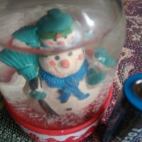 Коледна топка със снежен човек и валящ сняг
