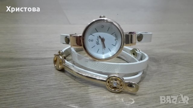 Часовник с камъчета и бяла каишка, усукваща се 2 пъти около китката