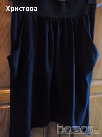 Къса черна асиметрична пола от трико с набор и джобове.