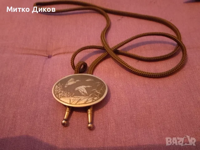 Ловно колие боло (bolo tie) с овална метална плакетка летящи патици сред тръстика