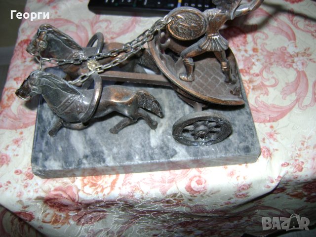 Стара метална склуптора върху мраморен постамент 