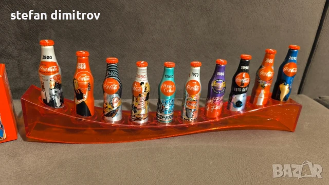 Coca Cola 100 години комплект бутилки, 10 мини алуминиеви бутилки с поставка, снимка 4 - Колекции - 51381112