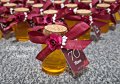 Шишенца с коркова тапа напълнени с мед и декорирани с сатенена лента и цветя