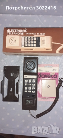Стационарен телефон слушалка със стойка за стена.