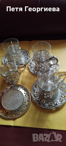 Стъклени чаши за кафе върху сребърни подстакани и чинийки