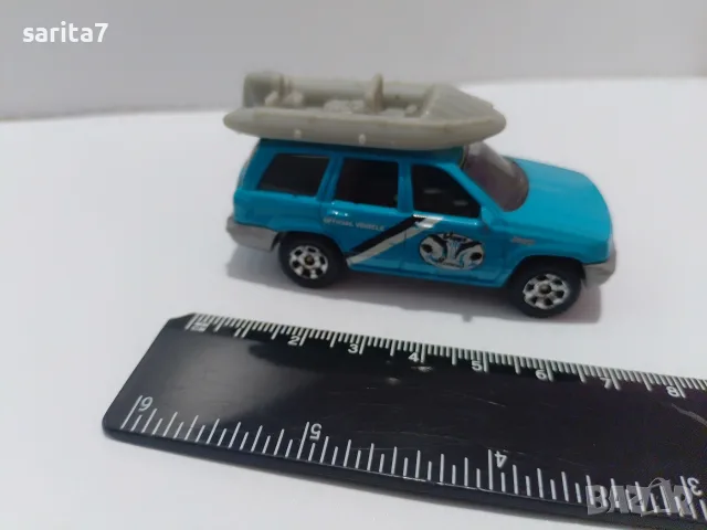 Jeep Grand Cherokee с лодка/сал на покрива на марката Matchbox (в мащаб около 1:58 – 1:64).