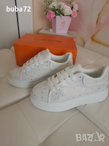 Белите маратонки на платформа с декоративни камъчета са от марката "Carolie"