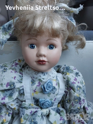 Кукла в цветном платье бело-голубого цвета.